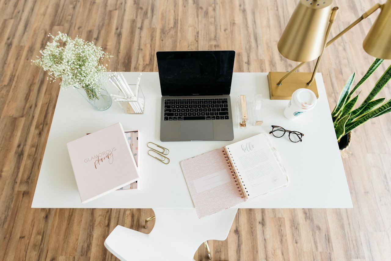 Organized desk with a laptop and planning materials for a small business